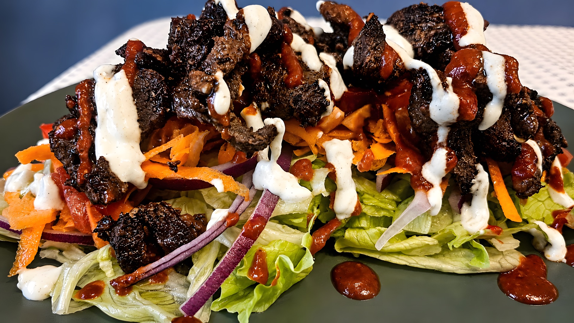 Grilled meat served on fresh salad with sauces